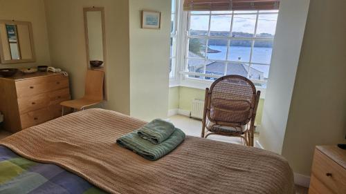 a bedroom with a bed and a large window at Charlies in Saint Mawes