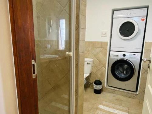 a bathroom with a washing machine and a washer at Stylish one bedroom apartment close to the beach in Langstrand