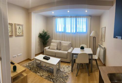 a living room with a couch and a table at Apartamentos Turisticos de Soria Collado 3 in Soria