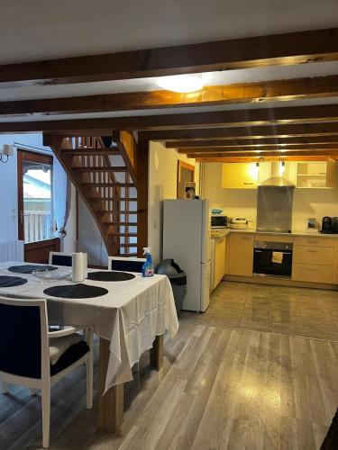 une cuisine et une salle à manger avec une table et un réfrigérateur dans l'établissement charmant trois pieces cosy, à Berstett