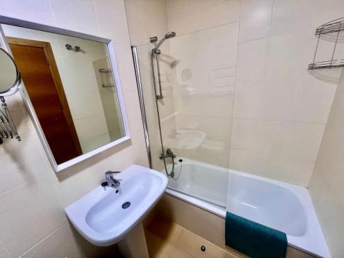 a white bathroom with a sink and a shower at Condado de Alhama PENTHOUSE SV11 in Alhama de Murcia