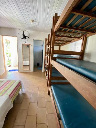 a room with two bunk beds and a mirror at Hostel Itaparica Casa in Itaparica