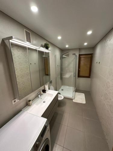 a bathroom with a sink and a toilet and a shower at Vingis Park Apartments with 2 Bedrooms & Free Parking in Vilnius