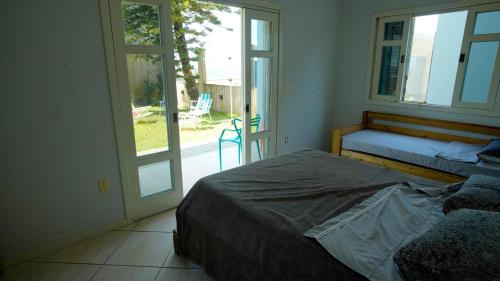 een slaapkamer met 2 bedden en een glazen schuifdeur bij OzeanHaus, Praia do Sol in Barra Velha