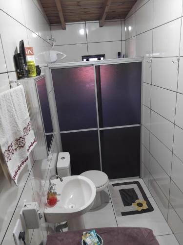 a bathroom with a shower and a toilet and a sink at Studio dos Canyons in Praia Grande
