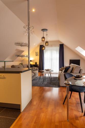 a kitchen and living room with a couch and a table at Hotel & Apartments Bibois Leuven in Oud-Heverlee