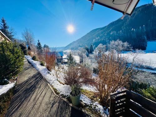 a snow covered road with trees and a mountain at Lodge am Fluss in Tamsweg