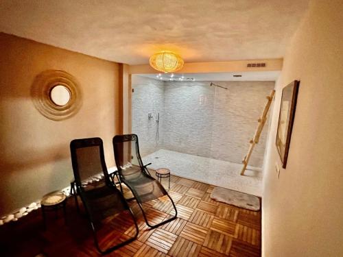 ein Bad mit einer Dusche und 2 Stühlen in einem Zimmer in der Unterkunft Casa Alegria - Holiday home with pool, fitness, sauna in Alcúdia