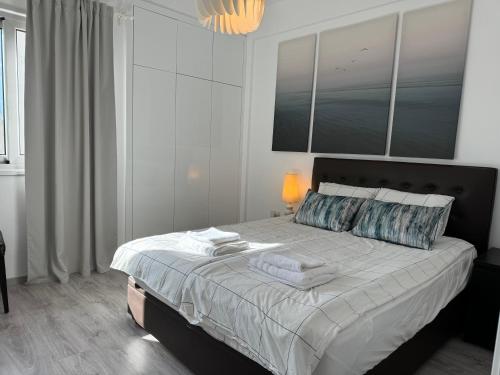 a bedroom with a large bed with towels on it at White 1-bdr apartment Agyos Tychonas in Limassol