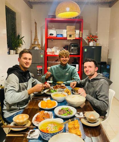 three men sitting at a table eating food at PIA homestay - Tours & Motorbike rentals - Cao Bằng in Cao Bằng
