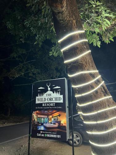 a sign next to a tree next to a sign at The Wild Orchid Resort Corbett in Rāmnagar