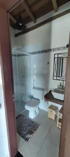 a bathroom with a shower and a toilet and a sink at Villa Girassol in Ilhabela