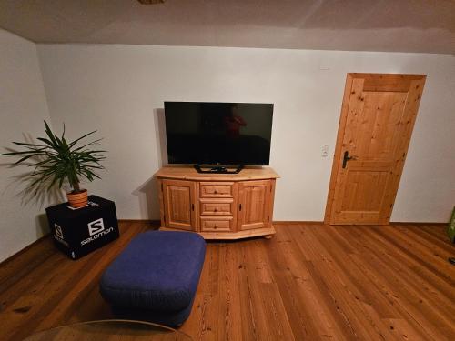 a living room with a tv on a wooden dresser at Haus Gaichtspitzblick in Weissenbach am Lech