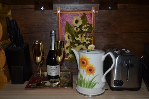 a table with a coffee pot and a bottle of wine at Traditional Log Cabin next to Harry Potter Studios in Kings Langley