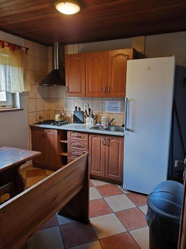 a kitchen with wooden cabinets and a white refrigerator at Zajazd U Doktora in Lubrza