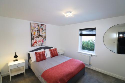 ブラックネルにあるBracknell Contemporary Stylish 3 bedroom inのベッドルーム1室(赤い毛布と鏡付きのベッド1台付)