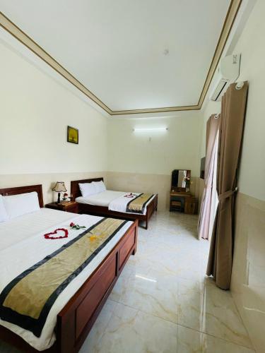 a hotel room with two beds and a room with at Magnolia Hotel Cam Ranh in Cam Ranh