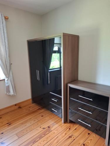 a bedroom with a dresser and a cabinet with a window at Meadow View in Gortatlea Junction