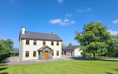 a large white house with a large yard at Meadow View in Gortatlea Junction