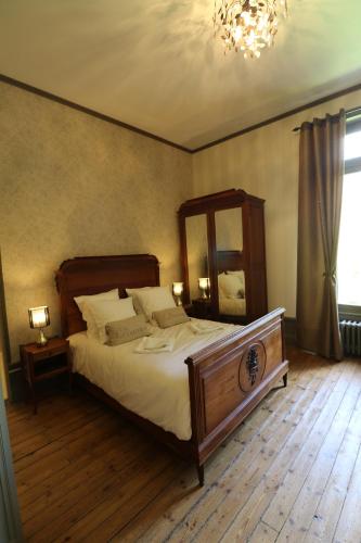 - une chambre avec un lit, un miroir et un lustre dans l'établissement Domaine de Champ rose + piscine chauffée, couverte, à Saint-Laurent-de-Belzagot