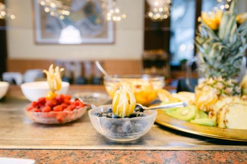 a table topped with bowls of fruit and other foods at Ambiance Hotel - Braunau - Simbach in Braunau am Inn
