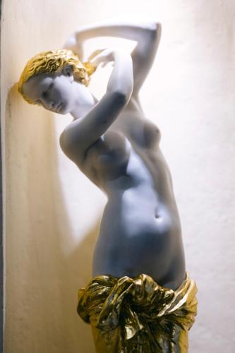 a statue of a nude woman in a gold dress at Ambiance Hotel - Braunau - Simbach in Braunau am Inn