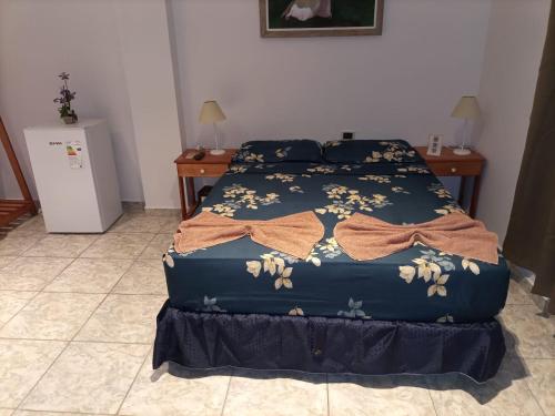 a bedroom with a bed with a blue comforter at Hotel Village del Sol in Puerto Iguazú