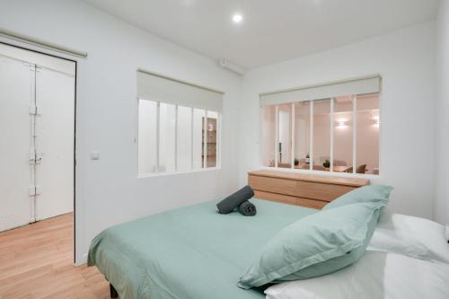 une chambre blanche avec un grand lit et une fenêtre dans l'établissement Cozy apartment in Saint-Germain-des-Prés, à Paris