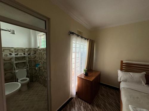a bathroom with a bed and a tub and a sink at Town Retreat Moshi in Moshi