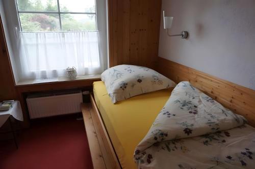 a small bedroom with a bed and a window at Ferienwohnung am Naturgarten in Waldbröl