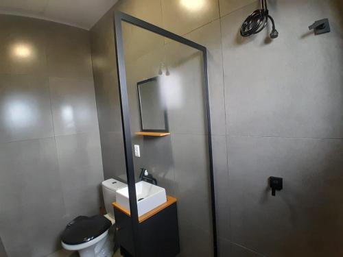 a bathroom with a toilet and a sink and a mirror at Casa nova a 2 min do mar in Arroio do Sal