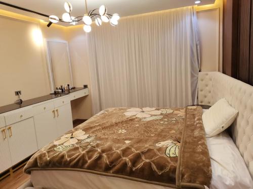 ein Schlafzimmer mit einem Bett mit einer Decke darauf in der Unterkunft Rental apartment in new Cairo شقة لك بالكامل in Kairo