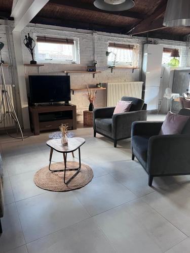 a living room with couches and a coffee table at Finca Noordwijk met privé tuin, dichtbij strand in Noordwijk