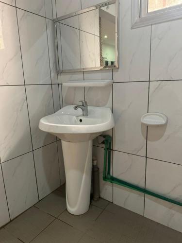 a bathroom with a white sink and a mirror at Motel Africa pas Chers in Conakry