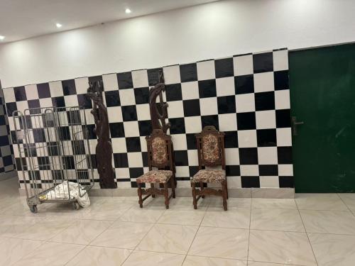 two chairs in a room with a checkered wall at Motel Africa pas Chers in Conakry