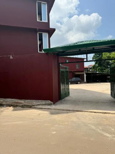 a red building with a green gate next to a building at Motel Africa pas Chers in Conakry