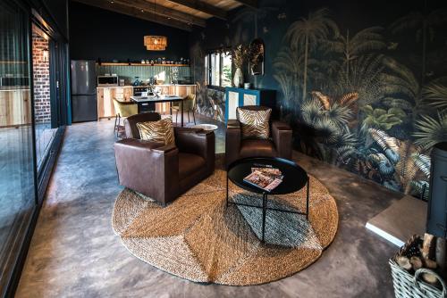 a living room with leather chairs and a table at Bains View Olive and Guest Farm in Wellington