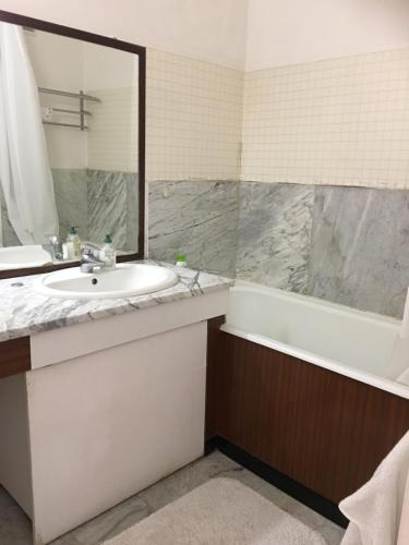 une salle de bain avec un lavabo, une baignoire et un miroir dans l'établissement Gardens, Pool and More !, à La Celle-Saint-Cloud