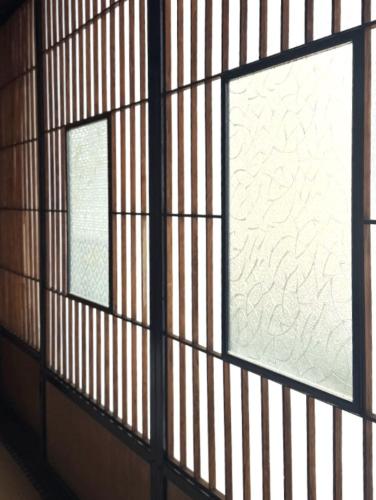 two windows in a room with wooden walls at Hosted Stay Minpaku Hallelujah in Matsumoto