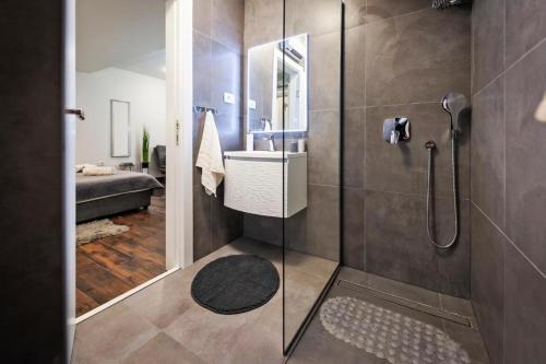 a bathroom with a glass shower with a sink at Deluxe Apartments A&A - 2 in Rovinj