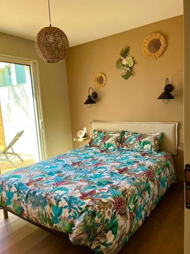 une chambre avec un lit avec une couette colorée dans l'établissement Sun Oasis L'Oasis, à Bretignolles-sur-Mer