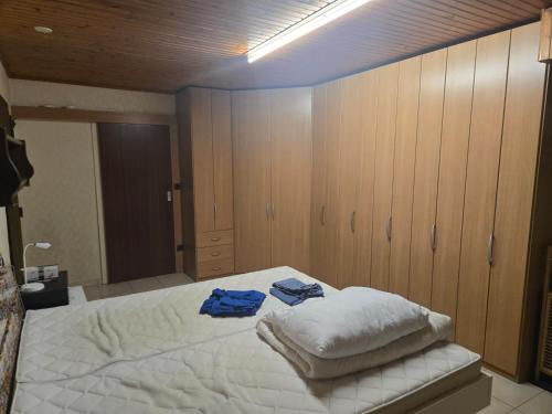 a bedroom with a large white bed with wooden cabinets at Messeapartment nahe Düsseldorf in Meerbusch