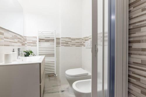 a white bathroom with a toilet and a sink at Casa Francesca - Cisanello in Pisa