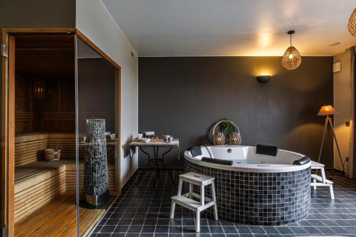 a bathroom with a tub and a table and a stool at B&B La Cereza in Oudenaarde
