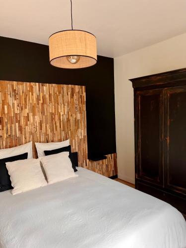 a bedroom with a large white bed with a wooden headboard at Appart'Alencon in Alençon