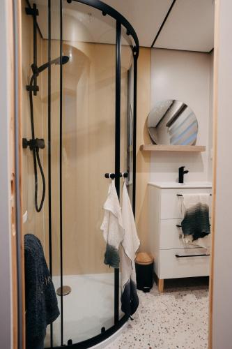 une douche avec une porte vitrée dans une salle de bain dans l'établissement Maison front de mer - plage du débarquement, à Bernières-sur-Mer