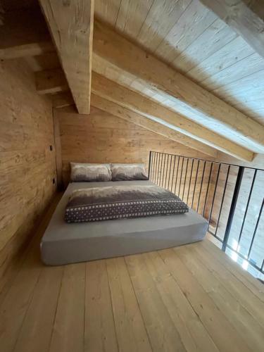 a bed in a room with wooden walls and ceilings at Sabbionaccio Apartments & Spa in Chiesa in Valmalenco