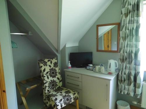 a room with a chair and a desk in a attic at Eas Dun Lodge in Donegal