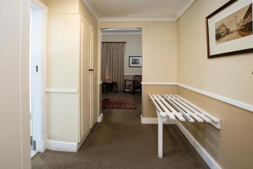 a hallway with a white bench in a room at Queen's Hotel by BON Hotels in Oudtshoorn