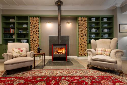 a living room with two chairs and a fireplace at Queen's Hotel by BON Hotels in Oudtshoorn